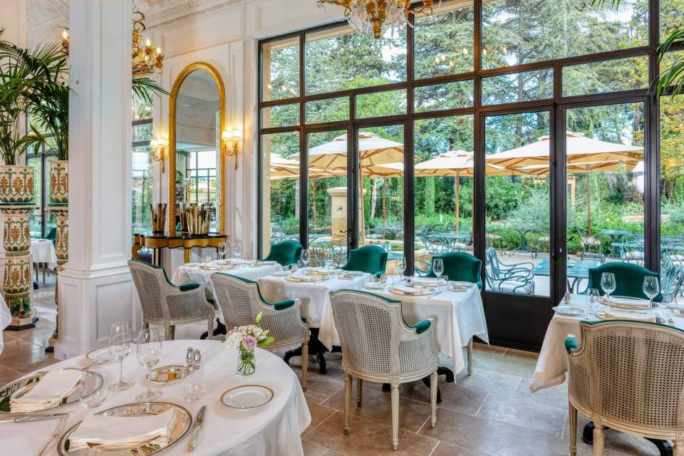 Salle de restaurant avec vue sur la terrasse et les jardins de la Villa Saint Ange